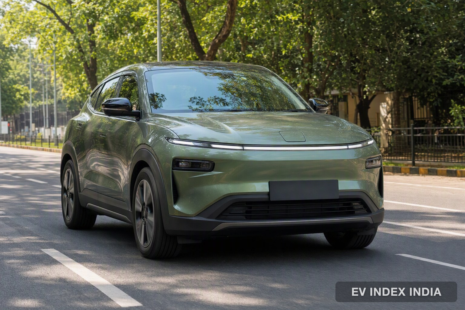 A green compact electric SUV on a leafy city street